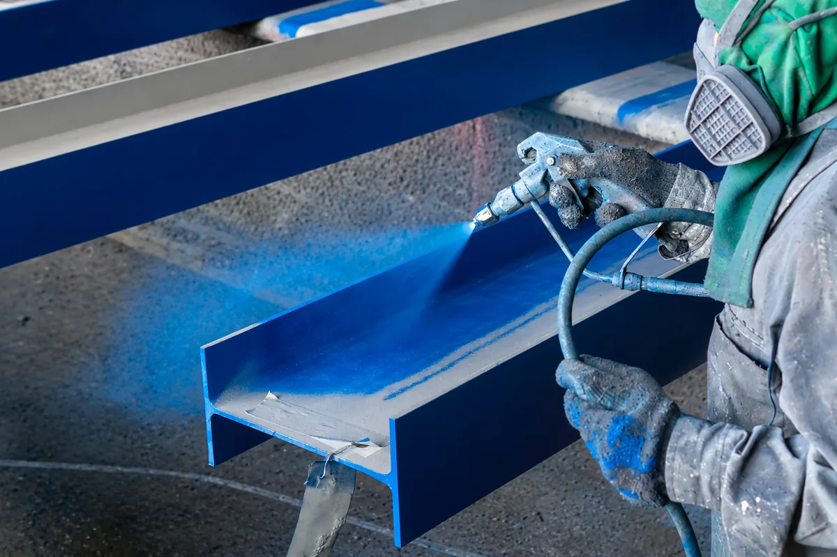 Application de peinture industrielle au pistolet sur une structure métallique